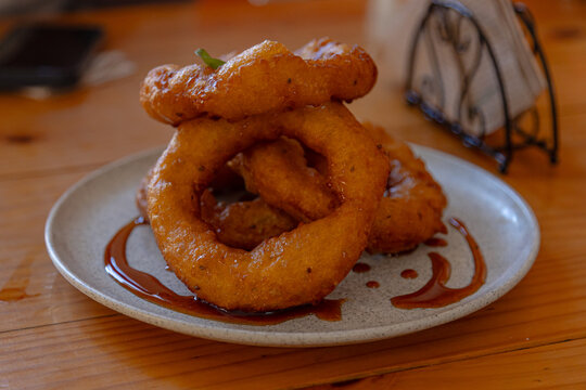 Traditional Peruvian picarones made with a soft dough based on squash and sweet potato, fried until golden and served with chancaca syrup.