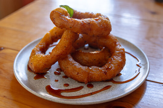 Traditional Peruvian picarones made with a soft dough based on squash and sweet potato, fried until golden and served with chancaca syrup.