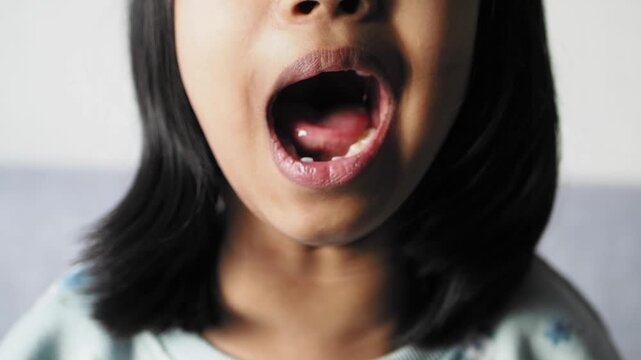 Close up of young girl opening mouth wide in surprise or speaking