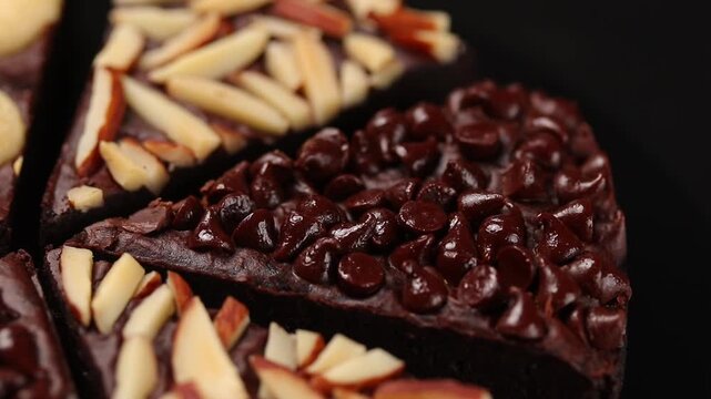 Close-up view of a chocolate chip fudge brownie rotating.