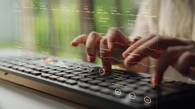 Hands are typing. Live infrastructure operations combine virtual machine activity with storage and replication metrics, giving context for the capacity and continuity of data services.