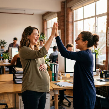 pregnant woman in her 30s high-fiving a coworker after a sma