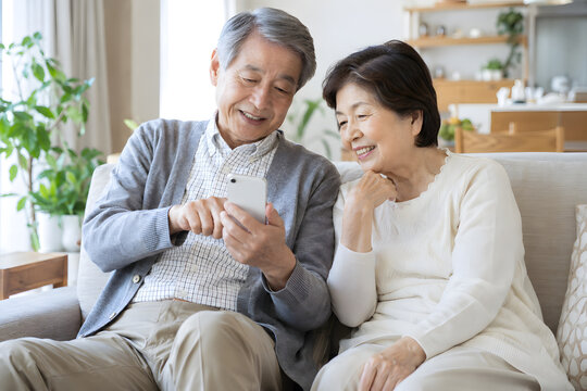 Elderly Japanese couple using a smartphone together at home