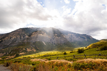 Obraz premium Sunlight Over Autumn Foliage and Rugged Wasatch Mountains Near Kyhv Peak Provo Utah