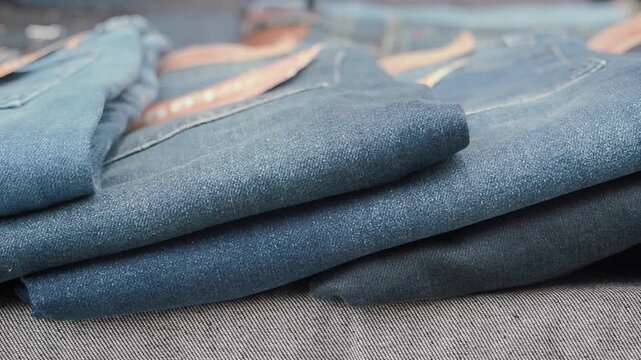 Denim jeans display in a store with various shades of blue fabric