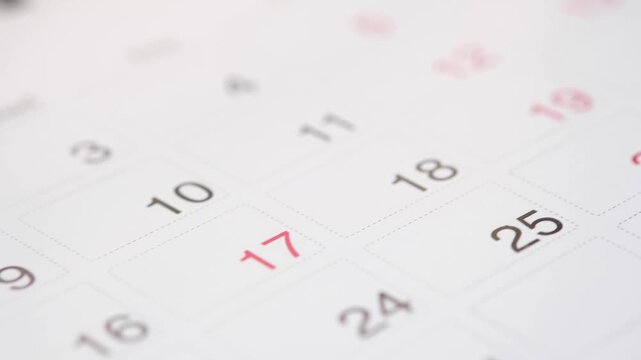 Close up of calendar pages turning with dates visible, representing time passing and planning