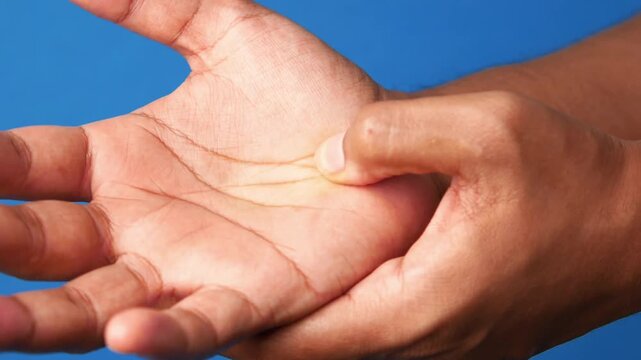 Person massaging palm of hand to relieve tension and pain
