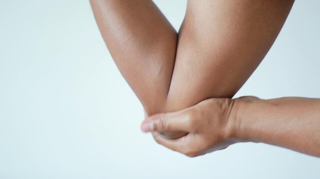 Close up view of hand gently massaging elbow joint showing pain relief and relaxation motion