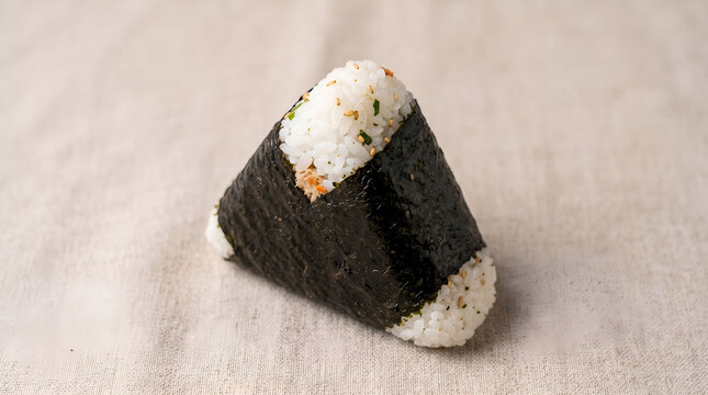 Korean triangle rice ball wrapped in seaweed on beige fabric