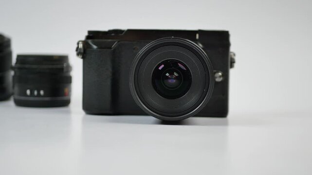 A motion footage of a professional black camera with a lens, other lenses moving into frame, modern photography equipment