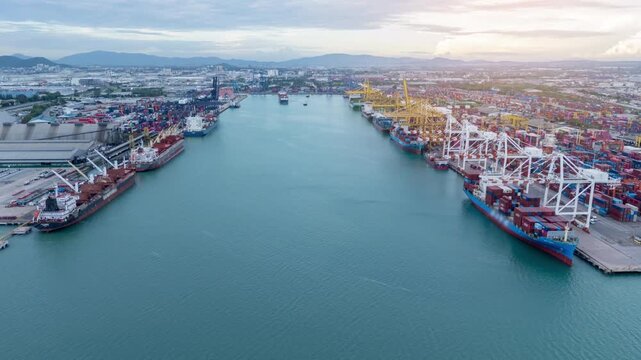 time lapse container ship fully loaded with cargo departing from a busy commercial seaport terminal at twilight. Global maritime logistics, international shipping trade, and freight transport concept.