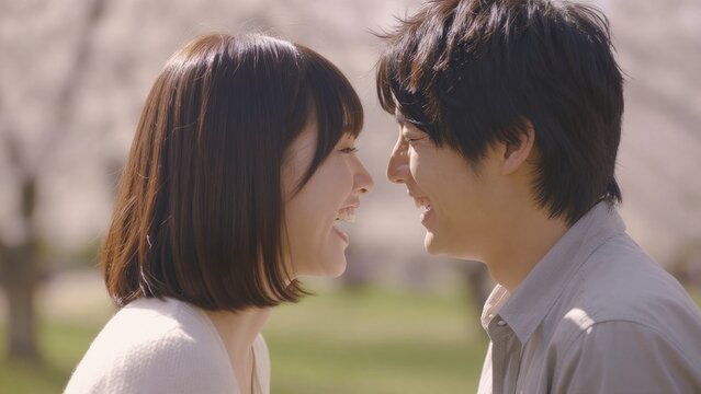 Joyful couple sharing laughter in a serene outdoor setting