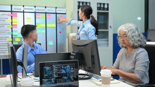 A diverse team of software developers collaborates on agile project management, brainstorming strategies at a kanban board in a modern tech office.