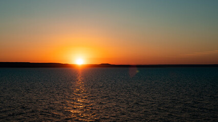 Fototapeta premium beautiful sunset at sea calm water ocean red orange colours