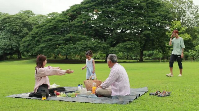 Father, Little girl walking and spending time with father in the park. Happy Asian family having fun time on picnic at city nature park, outdoor activitie