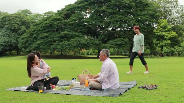 Father, Little girl walking and spending time with father in the park. Happy Asian family having fun time on picnic at city nature park, outdoor activitie