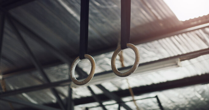 Gymnastic, rings and fitness in empty room or gym for workout, aerobic exercise and challenge. Balance, training and wellness with low angle of equipment in sports center for acrobatic and arena