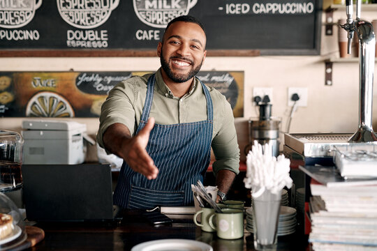 Cafe, barista or happy man with handshake for introduction, greeting or welcome in small business. Portrait, male person or restaurant owner shaking hands with smile for retail service in coffee shop