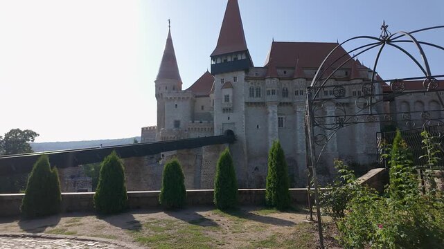 Corvin Castle facade and long entrance bridge viewed from gardens in Hunedoara Romania