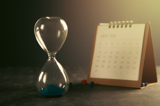 Hourglass and calendar on table. Time management concept.