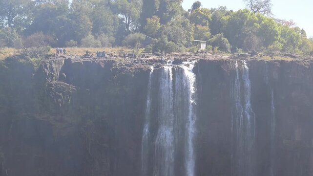People swimming in the Zambezi River rock pools at the top of Victoria Falls