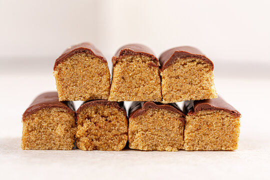 Traditional Kazakh sweet dessert zhent glazed with chocolate icing served in paper cups on wooden board