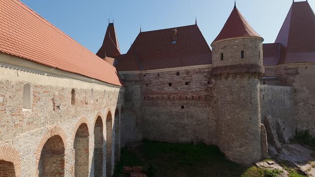 Arcaded fortified walls and red tiled roofs at Corvin Castle in Hunedoara Transylvania Romania