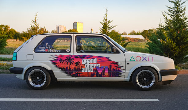 Bucharest, Romania - August 20, 2024: Modified white vintage Volkswagen Golf Mk2 hatchback car with Grand Theft Auto VI sunset decal livery parked outside. GTA concept.
