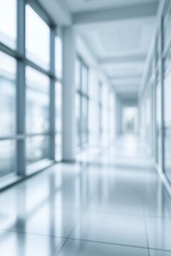 Blurry modern office corridor with large windows and