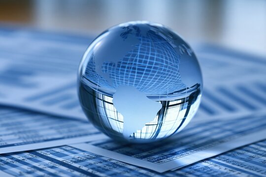 Glass globe reflecting global business data on documents