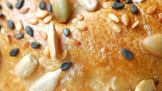 Close up cinematic footage of seeds on whole grain bread, macro video of healthy baked food texture with various nuts and grains, organic ingredients for nutritious breakfast