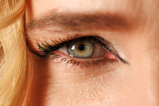 Close-up of a human eye with green irises and dark eyeliner