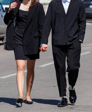 Couple walks hand in hand on city street