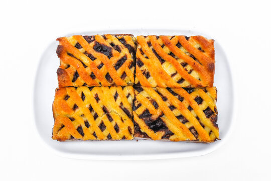 Delicious homemade banana and chocolate filled cake slices arranged on a wooden serving board isolated on a white background.