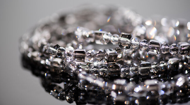Crystals bracelet or necklace, gems, diamonds over black background, beautiful gems, rhinestones, brilliants sparkling with colorful rainbow lights. Moissanite. Zirconia. Border design
