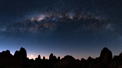 Obraz premium Milky Way galaxy above rocky mountain silhouettes