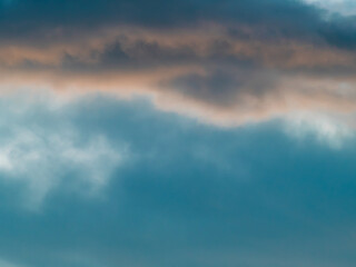 Obraz premium Dramatic Blue-Teal Storm Clouds with Warm Sunset Light Peeking Through