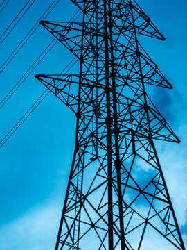 High Voltage Electricity Transmission Tower Pylon Viewed from Below Against Dusk Sky