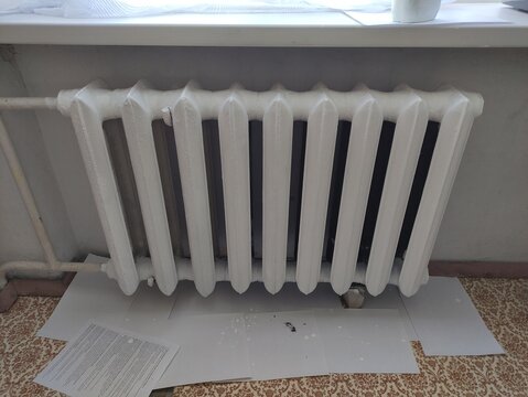Freshly painted white cast iron radiator with new coat of paint in a room