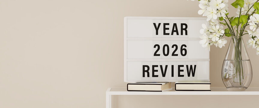 A lightbox displaying the words "Year 2026 Review" on a shelf with books and plants. Copy space, web banner format.
