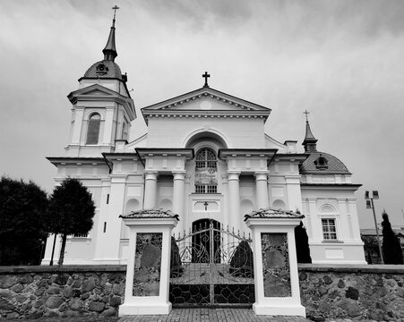 Monochrome symmetric facade of a classical Catholic church with columns and stone wall