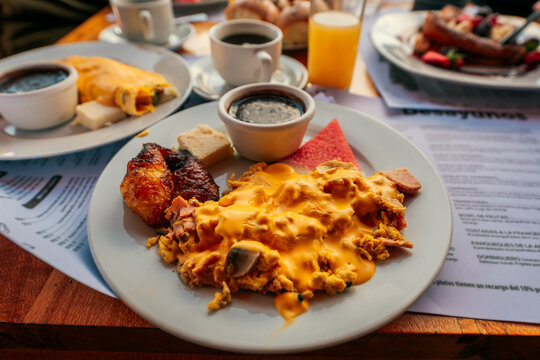 Closeup of a traditional Guatemalan breakfast. Traditional Chapin breakfast: scrambled eggs with melted cheese sauce and fried ripe plantain