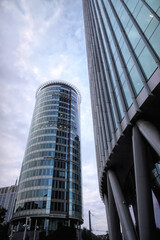 Obraz premium Brussels North, Belgium Low angle view of modern high rise glass corporate office skyscrapers architecture under cloudy sky