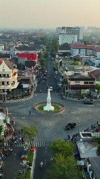 Vertical aerial cityscape centered on iconic Tugu Jogja monument and roundabout