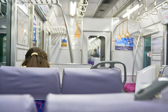 A passenger sits quietly on a purple seat inside a nearly empty commuter train carriage Ideal for sustainable transportation editorials and regional travel guides highlighting public transit