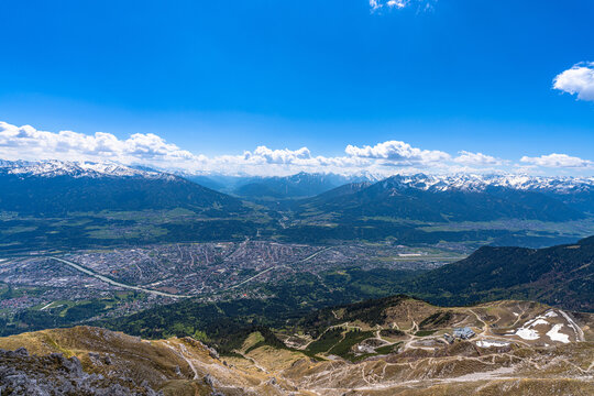 Stunning aerial panorama view of Innsbruck cityscape and the massif of Alps in Tyrol from Hafelekarspitze peak in spring on a sunny day, Innsbruck, Austria