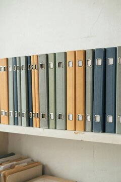 Shelf of ring binders with blank spine labels in a plain office archive