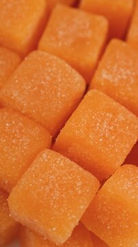 Orange cubes creatine gummies close up, rotation