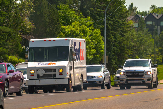 Calgary, Alberta, Canada. September 18, 2026. A FedEx delivery truck and traffic driving along a sunny suburban street during the day
