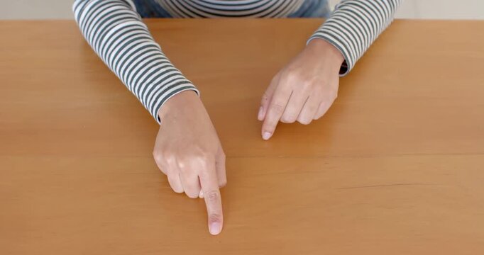 Close up of people talking to the camera, pointing at wooden table, person wearing striped shirt, fo
